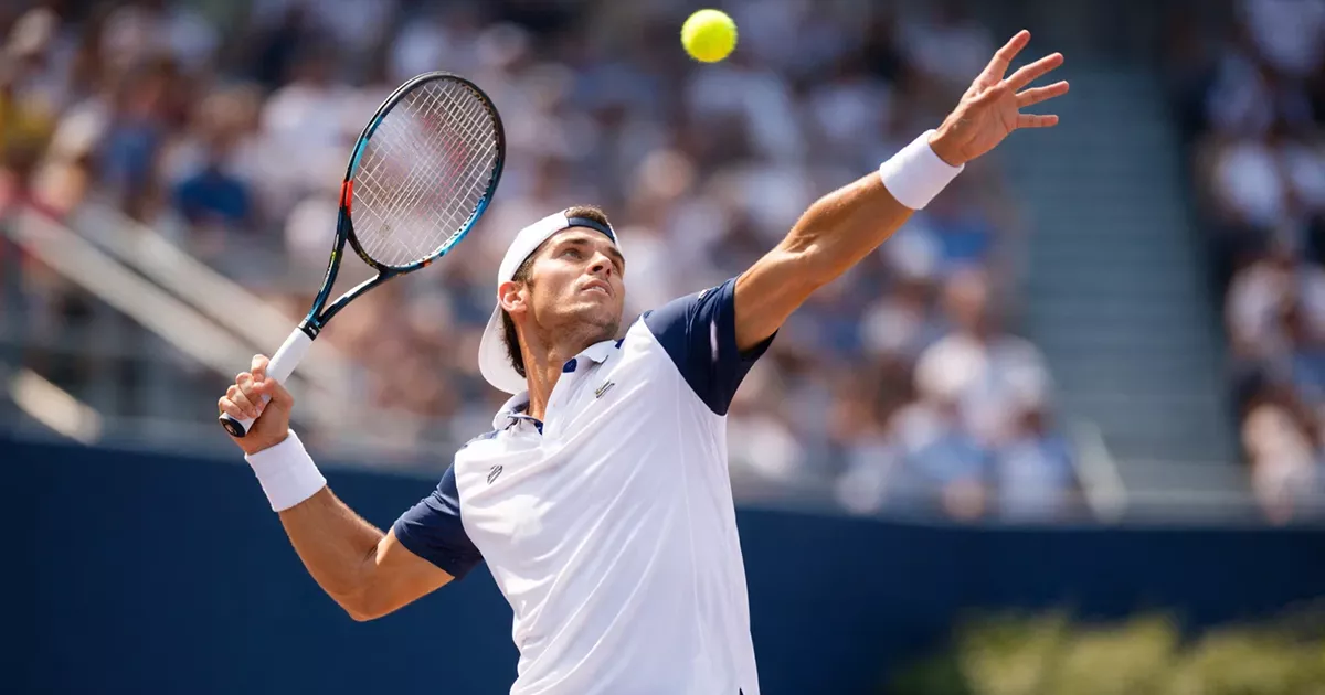 Tenista profesional ejecutando un potente saque en partido oficial